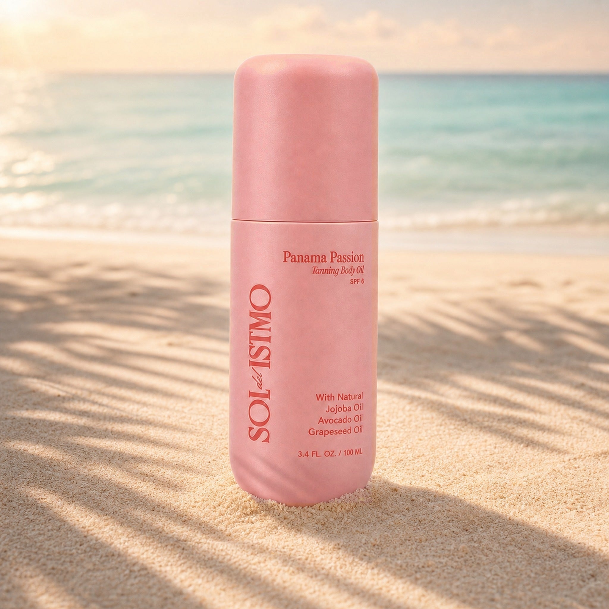 Panama Passion Tanning Body Oil bottle standing in beach sand with palm shadows