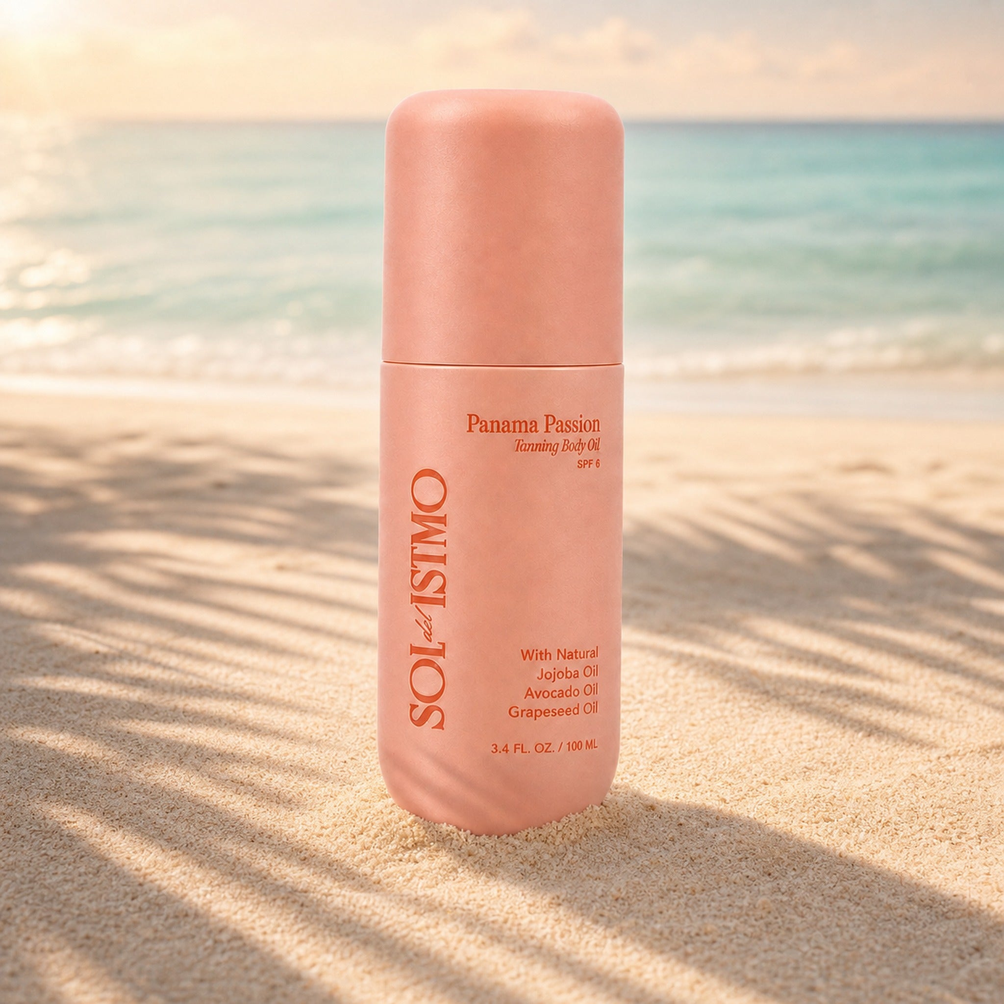 Panama Passion Tanning Body Oil bottle standing in beach sand with palm shadows