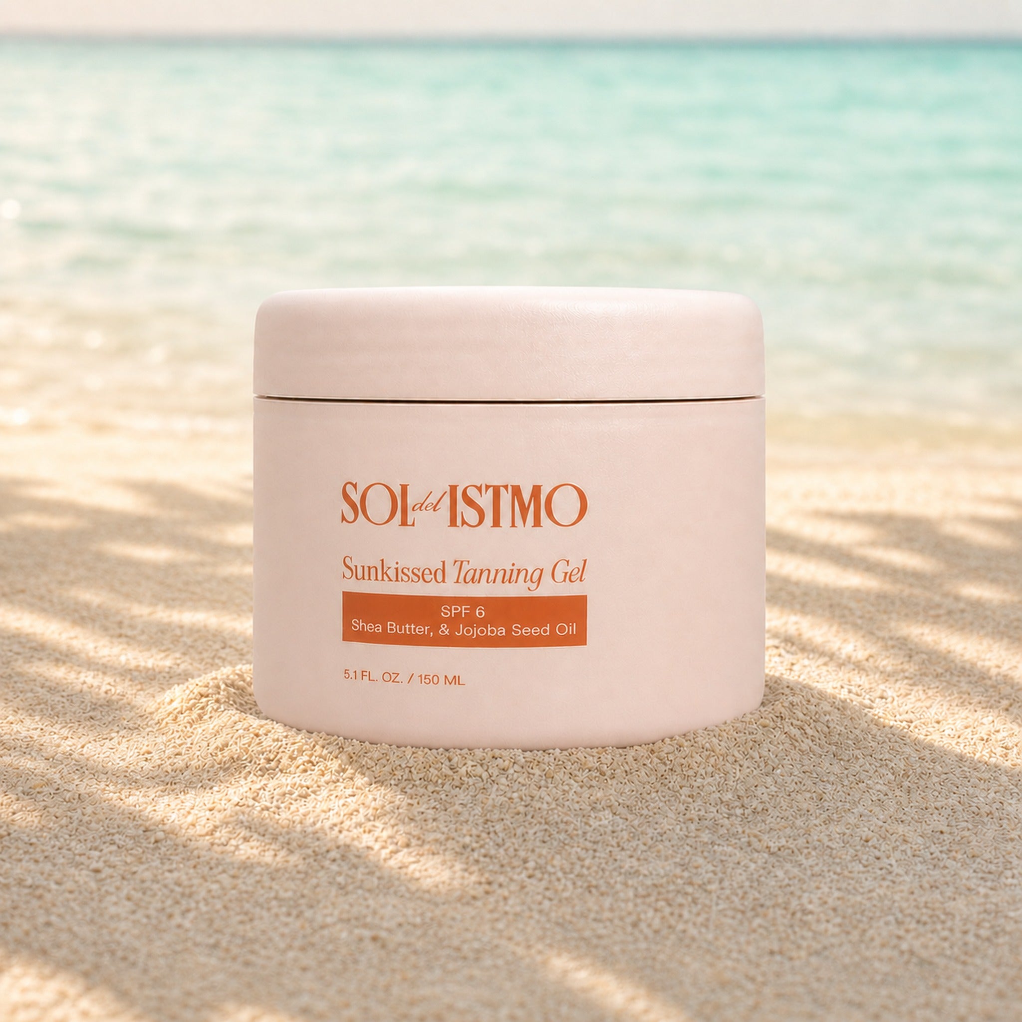 Sunkissed Tanning Gel jar standing in beach sand with palm shadows